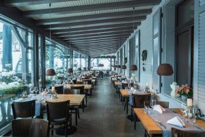 a restaurant with tables and chairs and windows at The Alpina Mountain Resort in Tschiertschen