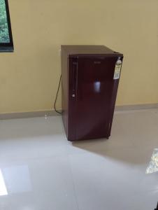 a brown refrigerator sitting on the floor in a room at Grace Green Holiday Home in Benaulim
