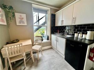a kitchen with a table and a dining room at Island View in Benllech
