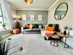 a living room with a couch and a mirror at Island View in Benllech