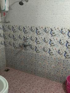 a bathroom with a toilet and a tiled wall at Grace Green Holiday Home in Benaulim +63 photos
