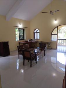 a living room with tables and chairs in it at Grace Green Holiday Home in Benaulim
