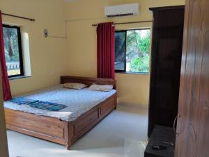 a bedroom with a bed and two windows at Grace Green Holiday Home in Benaulim