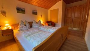 a bedroom with a large bed with white sheets and pillows at Ferienhof Hochbrandt in Spital am Pyhrn