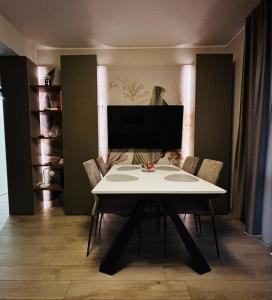 a dining room with a white table and chairs at Ales apartment in Cuneo