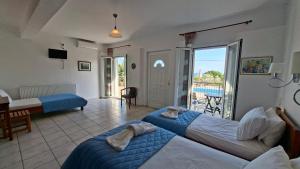 a hotel room with two beds and a balcony at Ninareti Studios in Agia Paraskevi