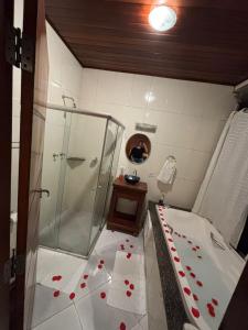a bathroom with a shower with red hearts on the floor at Chalé Recanto do Sol in Paraisópolis +18 photos