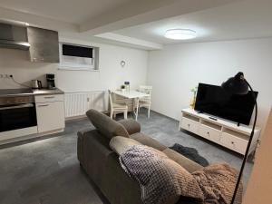 a living room with a couch and a tv and a kitchen at Ferienwohnung Meister in Mayen