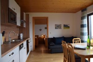 a kitchen and living room with a table and a couch at Ferienhof Hochbrandt in Spital am Pyhrn