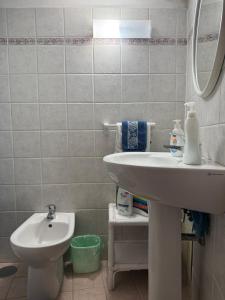a white bathroom with a sink and a toilet at Ponzamania Terrazza sul tramonto in Ponza