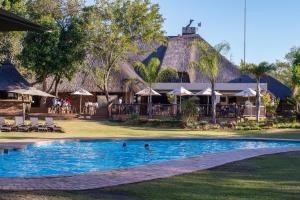 a pool at a resort with people swimming in it at Kruger Park Lodge Unit No 219 in Hazyview