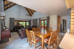 a dining room with a wooden table and chairs at Kruger Park Lodge Unit No 219 in Hazyview