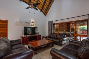 a living room with leather furniture and a flat screen tv at Kruger Park Lodge Unit No 219 in Hazyview