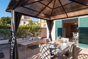a patio with a table and chairs and an umbrella at Del Prado in Riva Ligure