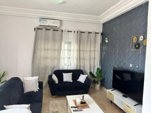 a living room with a blue couch and a tv at Dares Salaam in Cotonou