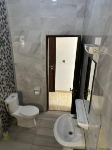 a bathroom with a toilet and a sink and a mirror at Dares Salaam in Cotonou