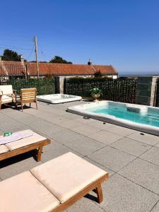 a patio with a swimming pool and two chairs and a table at Lodge 17 St Andrews in St. Andrews