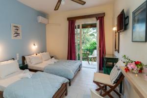 a hotel room with two beds and a balcony at Hara Studios in Laganas