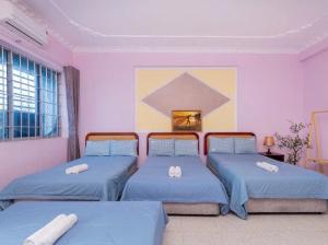 two beds in a room with blue beds in it at The Warm khách sạn bãi sau giá rẻ in Vung Tau