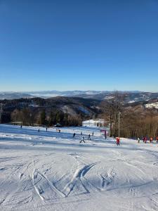 a group of people skiing down a snow covered slope at Pod strechou Kysúc in Oščadnica