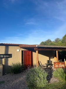 a house with a red door and a patio at La Luna in Villa Serrana +17 photos
