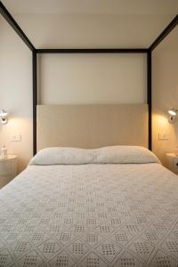a bedroom with a large white bed with two lights at CasaCeciliamare in Ortona