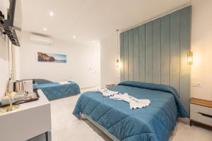 a bedroom with two beds with blue comforter at Affittacamere Sulle Stelle in La Spezia
