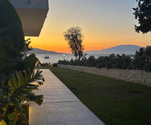a sunset over the water with a pathway at Ayïa suites in Alikanas