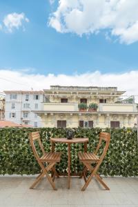 a table and two chairs in front of a hedge at Affittacamere Sulle Stelle in La Spezia
