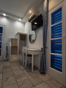 a room with a table and a mirror and a table and chairs at Sea View Studios & Apartments in Agia Anna Naxos
