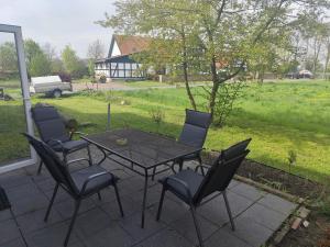 a patio with a table and chairs and a field at Gästehaus Ruhepol in Bissendorf