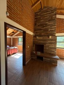 a brick fireplace in a room with a bed at Del Cortes Cabañas in Velasco