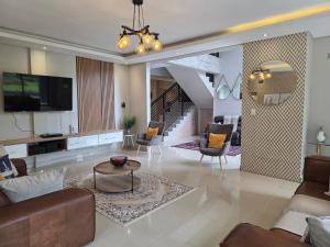 a living room with a couch and a tv at Eastern Road Executive Suites in Harare
