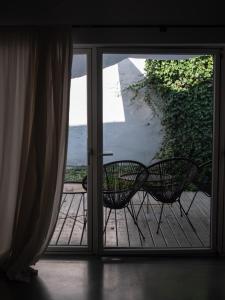 a sliding glass door with two chairs on a porch at Casa Blanca Łagów in Łagów