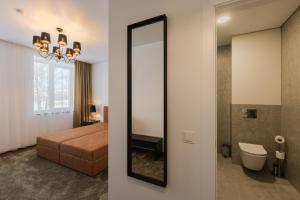a bedroom with a mirror and a bed and a bathroom at Varenastay in Varėna +61 photos