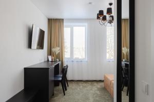 a living room with a black desk and a window at Varenastay in Varėna