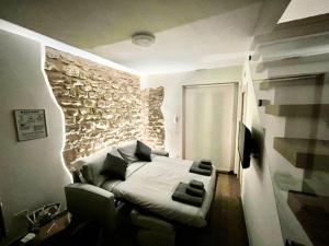 a bedroom with a bed and a stone wall at L'Angolo della Torre in Bevagna