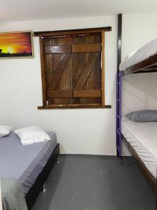 a room with two bunk beds and a window at Pousada Valverde Suíte 2 in Rio de Janeiro