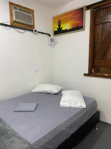 a bedroom with a bed with a window and a window at Pousada Valverde Suíte 2 in Rio de Janeiro