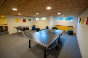 a room with a ping pong table and a table at Brentsch B56 in Scuol