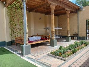 an outdoor patio with a bed and some plants at Marvarid INN in Samarkand