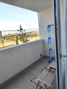 two chairs in a room with a balcony with a view at Nuevo departamento cercano a playa y comercio in Viña del Mar