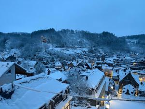 a small town covered in snow at dusk at Felsenhäuschen in Monschau
