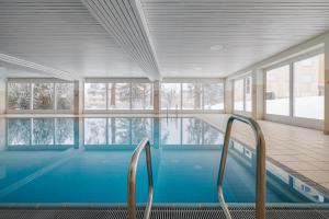 a swimming pool in a building with windows at Brentsch A6 in Scuol