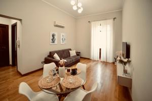 a living room with a table and chairs and a couch at Dimora Beatrice in Termini Imerese