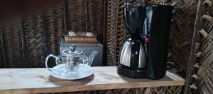 a coffee maker on a table next to a coffee pot at Zamani Matemwe House in Matemwe