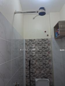 a bathroom with a shower with a stone wall at Shalom - Stays in Voi +16 photos