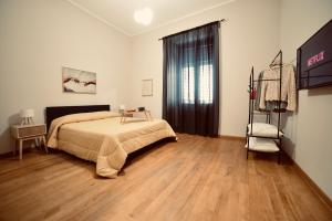 a bedroom with a bed and a wooden floor at Dimora Beatrice in Termini Imerese