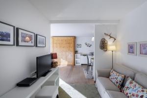 a living room with a couch and a television at Brentsch A27 in Scuol