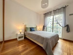 a bedroom with a bed and a large window at Sea Soul residencial in Funchal